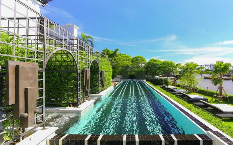 An outdoor swimming pool at The Siam Bangkok overlooks the beautiful Phraya River